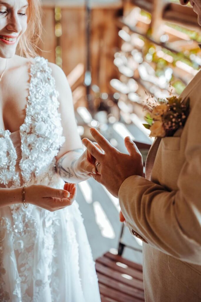 Braut steckt dem Bräutigam den Ring an bei einer Hochzeit auf der Tiefmatt in Oberbuchsiten