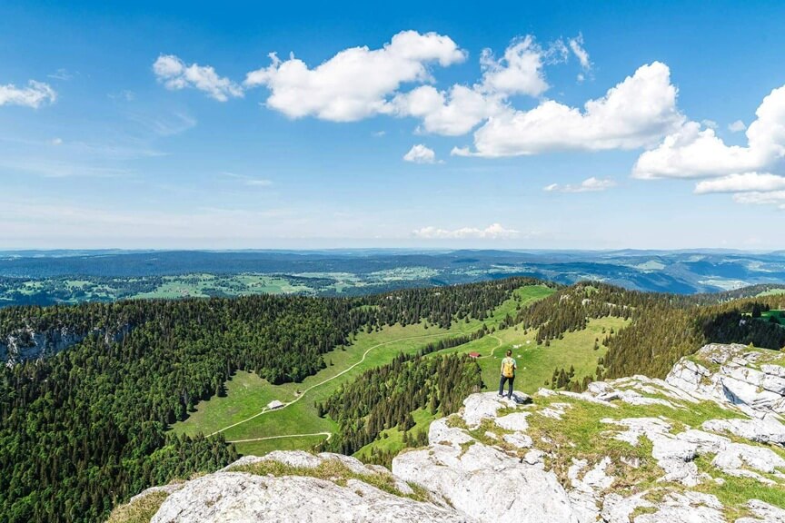 Wanderer auf dem Jura-Höhenweg mit weiter Aussicht über die Landschaft der Region Solothurn