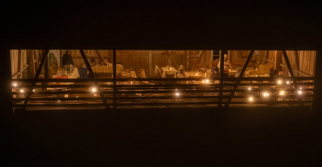 Drohnenaufnahme des festlich beleuchteten Schopfs beim Bergrestaurant Tiefmatt in Oberbuchsiten bei einem Abendanlass